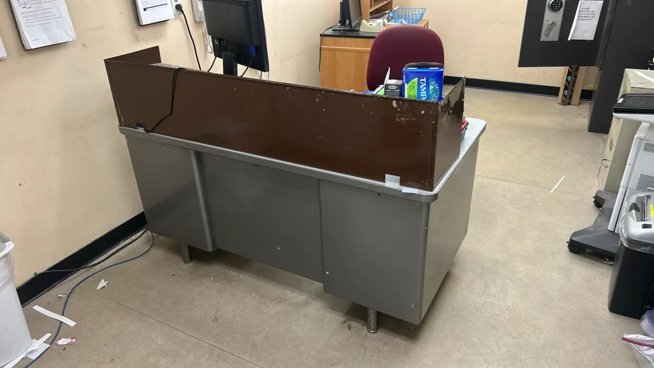 Office furniture and supplies lot. Includes a 60" x 30" metal double-pedestal desk with laminate top and upper shelf riser, an armless cushioned offic
