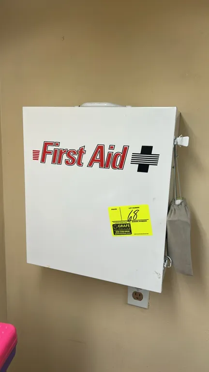 Metal wall-mounted first aid cabinet. Features a white finish, 3-tier interior, dual side latches, top carrying handle, and pre-drilled wall mounting