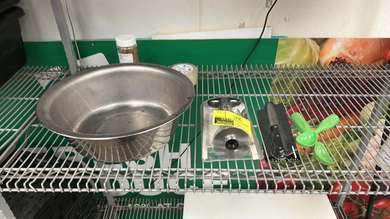 Assorted food preparation utensils. Includes stainless steel prep bowl with drain holes, pineapple corer and slicer, stainless steel utility knife, an