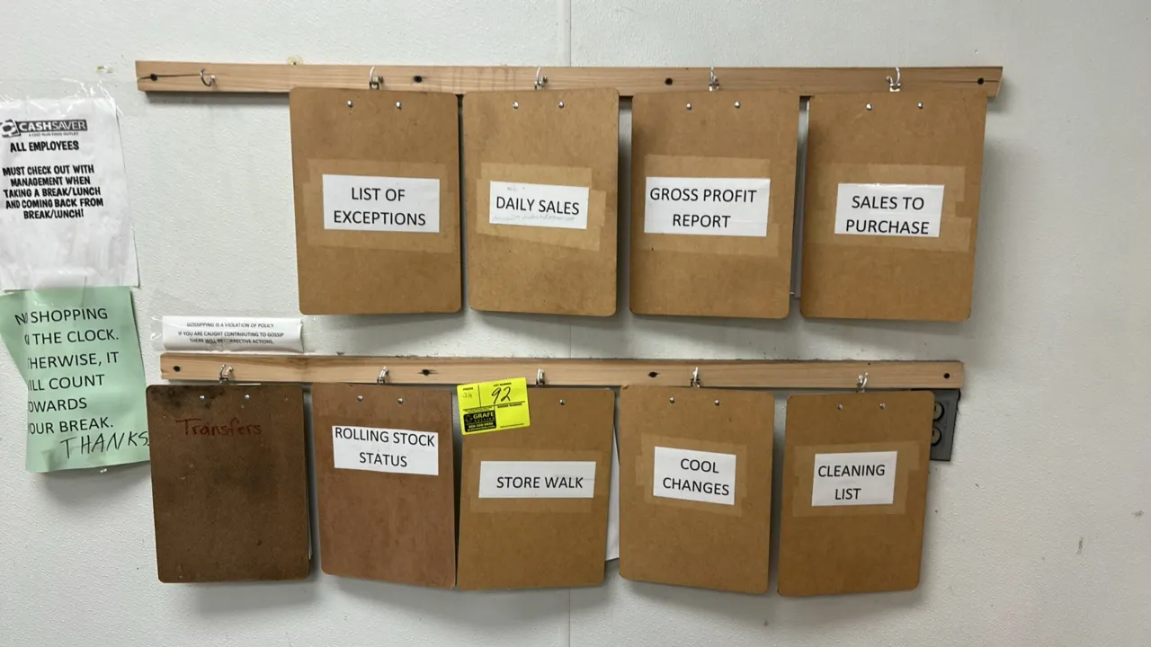 Hardboard clipboard set. Includes (9) hardboard clipboards with metal clips and (2) wall-mounted wooden hanging strips with hooks.