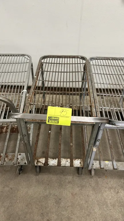 Metal 2-tier stock cart. Features an upper wire shelf, lower slatted shelf, and integrated push handle. 3'L. Mounted on casters.