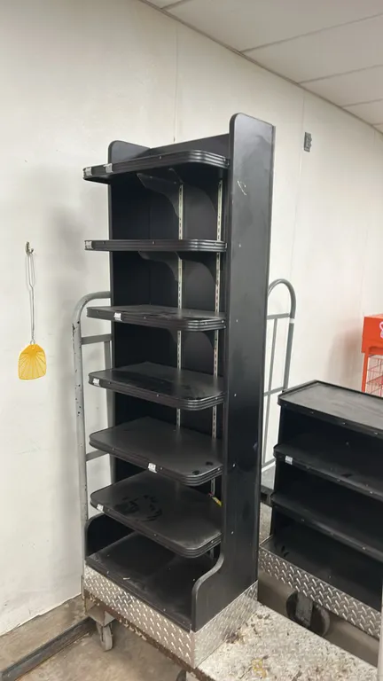 Laminate multi-tier display shelves. Features black laminate construction, adjustable shelves with edge molding, and diamond plate metal base trim. Di