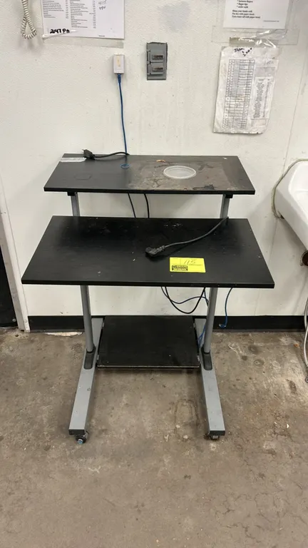 VIVO mobile workstation cart. Features multi-tier black laminate shelves including upper monitor shelf, main work surface, and lower storage shelf. Gr