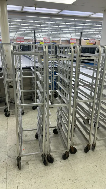 Winholt aluminum front-load meat platter racks. Features angle slide runners and welded tubular aluminum frame. Mounted on swivel casters.