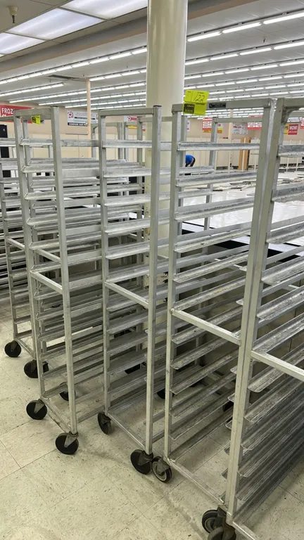 Aluminum front-load meat platter racks. Features welded aluminum construction with angled tray runners. Mounted on swivel casters.