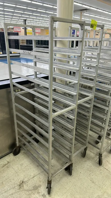 Aluminum front-load meat platter racks. Features welded aluminum construction with angled tray slides. Mounted on swivel casters. Note: Select tray sl