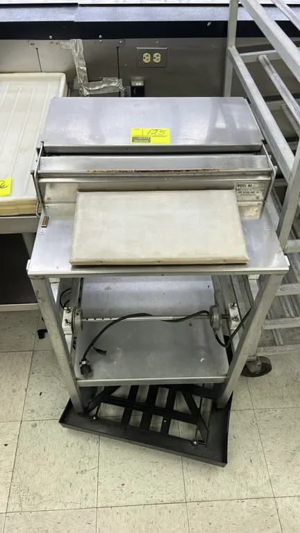 Heat Seal 107-A stainless steel wrapping station. Features a heated seal plate, cut-off bar, front wrapping surface, film roll dispenser rack, and low