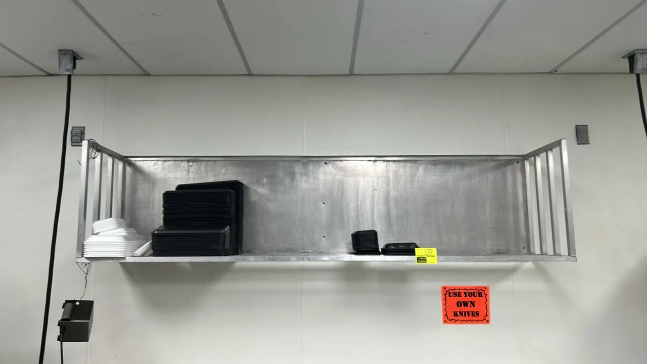 Wall-mounted metal shelf. Features a solid back panel, slatted bottom shelf, and tubular side guard rails. 96"W x 18"D. Designed for wall mounting. Co
