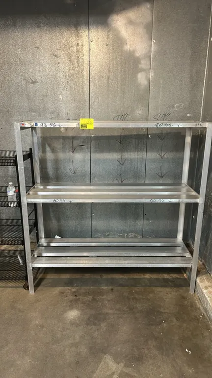 Stainless steel 3-tier storage rack. Features welded frame construction and 3 slatted shelf tiers. Dimensions: 60" x 20".