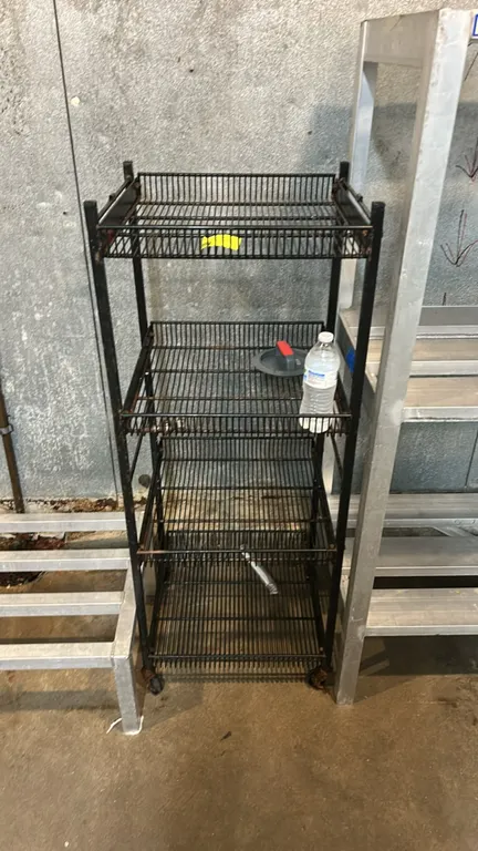 Portable 4-tier metal wire rack. Features a black-finished metal frame with wire shelving tiers. Mounted on casters. Contents not included.