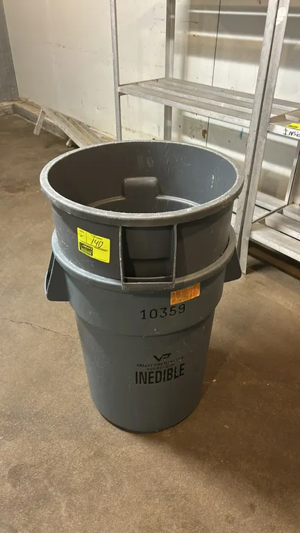Poly bulk trash bins. Features molded plastic construction and integrated side handles. Marked "Inedible". Contents not included.