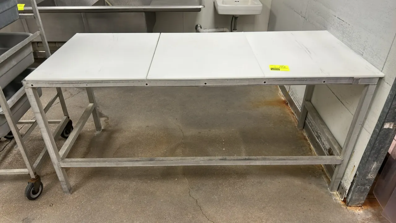 Metal prep table. Features a 3-piece poly cutting board top and metal frame with lower cross-brace support. 72" x 30".