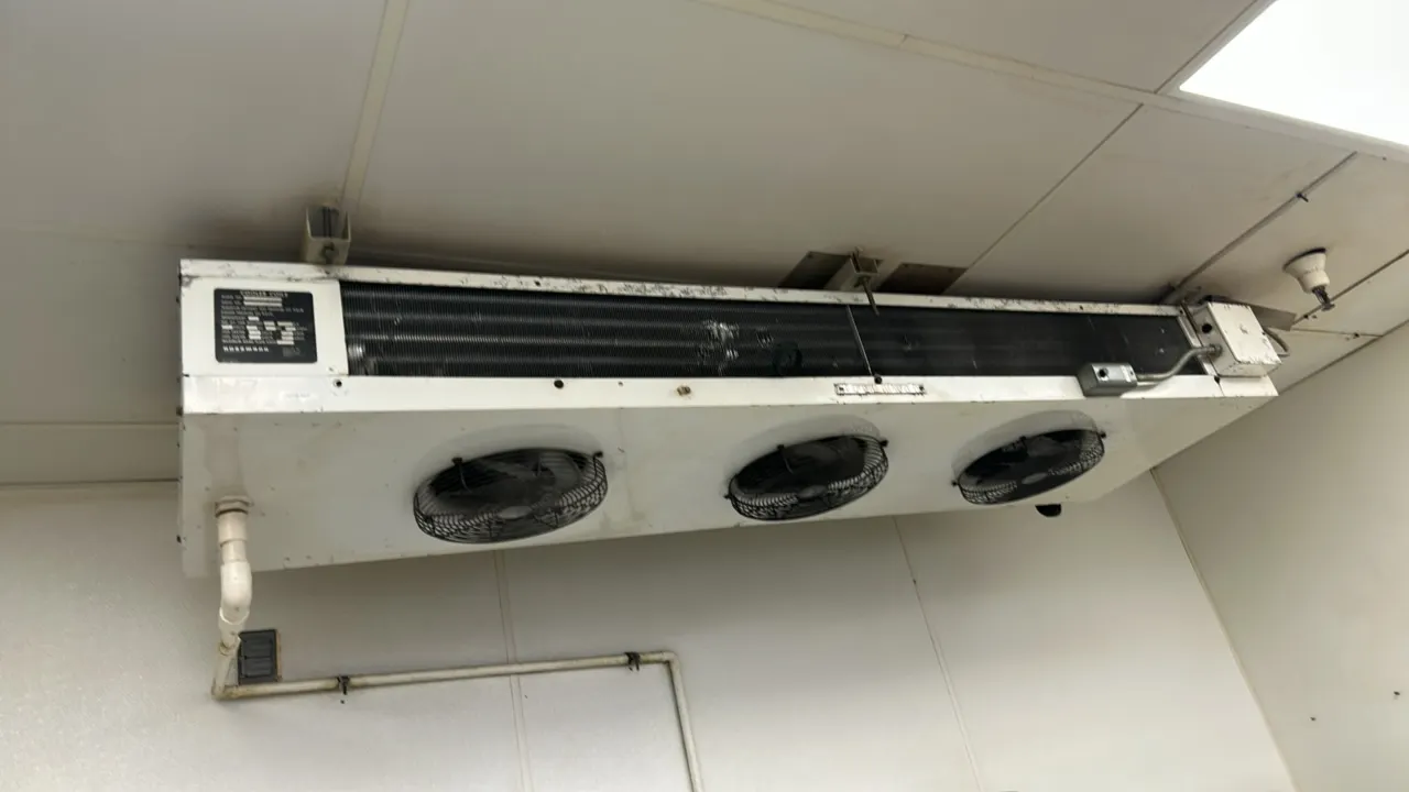 Hussmann 3-fan walk-in cooler evaporator coil. Features ceiling-mount configuration, three fan assemblies with wire guards, and exposed finned coil.