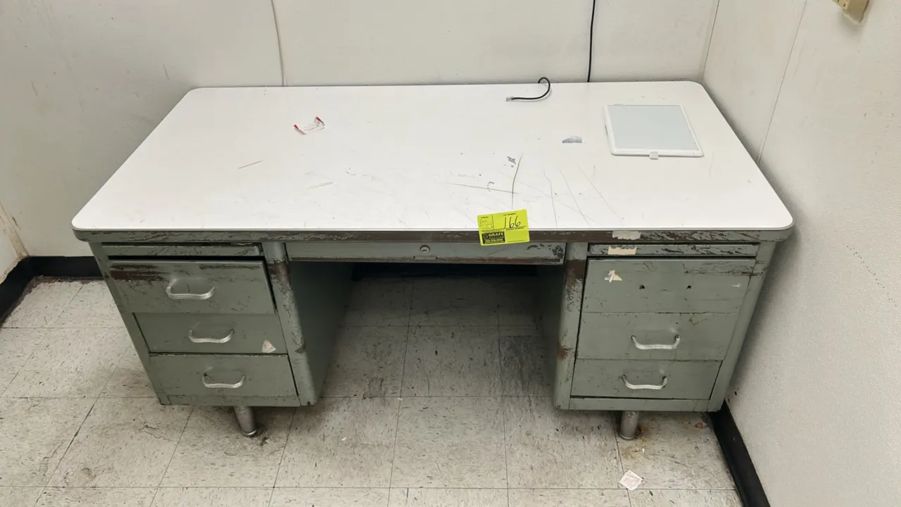 Office furniture lot. Includes 60" x 30" metal double-pedestal desk with laminate top, metal 4-drawer vertical filing cabinet, and wood-framed corkboa