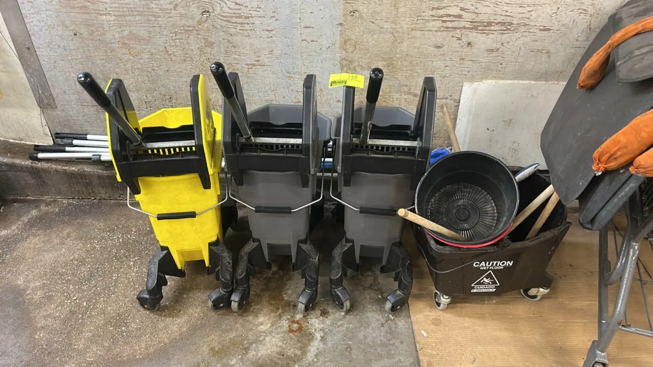 Mobile poly mop buckets with assorted cleaning accessories. Includes mop buckets with wringers, lobby dustpan, brooms, mop handles, and assorted clean