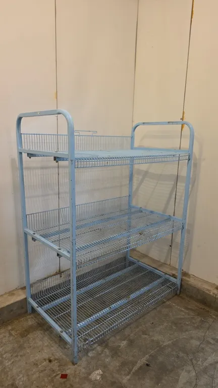 Metal 3-tier wire rack. Features a light blue finish, (3) wire shelves with rear wire retainers, and tubular metal side frames with integrated top han