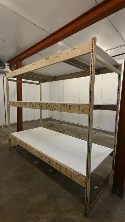 8'L of metal warehouse racking. Features 3'8" x 7' uprights, 5" crossbars, and 3 shelf levels with compressed wood decking.