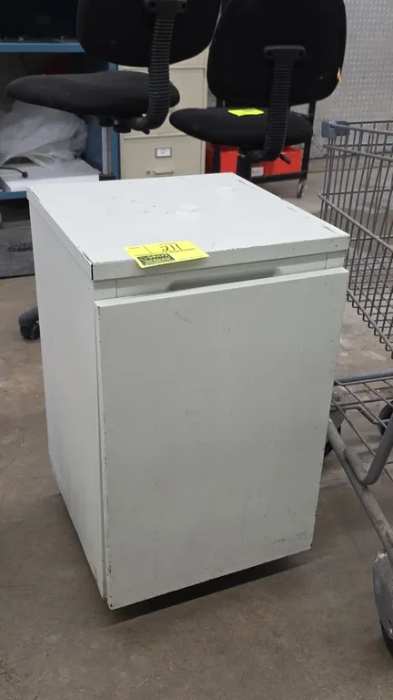 Portable metal storage cabinet. Features a single hinged door with recessed pull handle and one interior shelf. 27"H.
