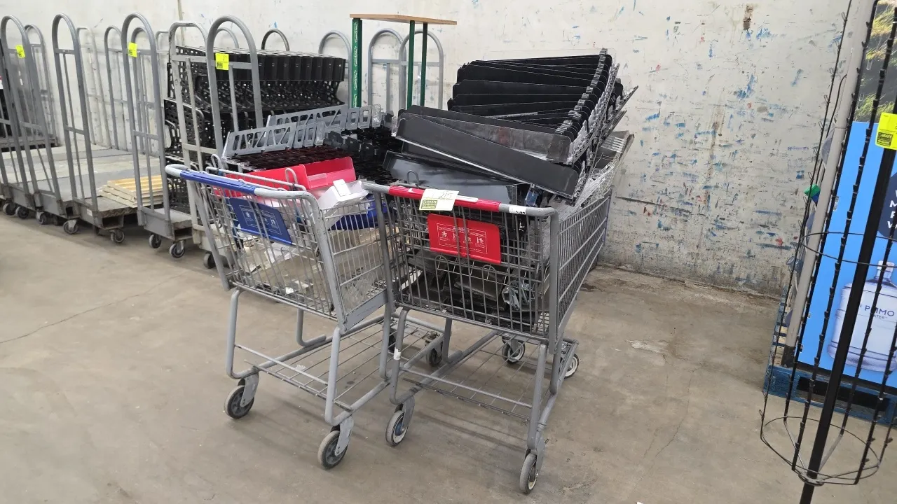 Wire shopping carts. Features tubular metal frames with wire baskets, lower storage trays, rear folding child seats, and plastic handle trim. Mounted