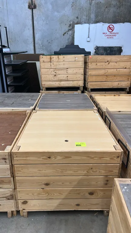 Wooden produce dump display bins. Features wood slat construction with raised display inserts. 48" x 40". Mounted on pallet-style bases for forklift a