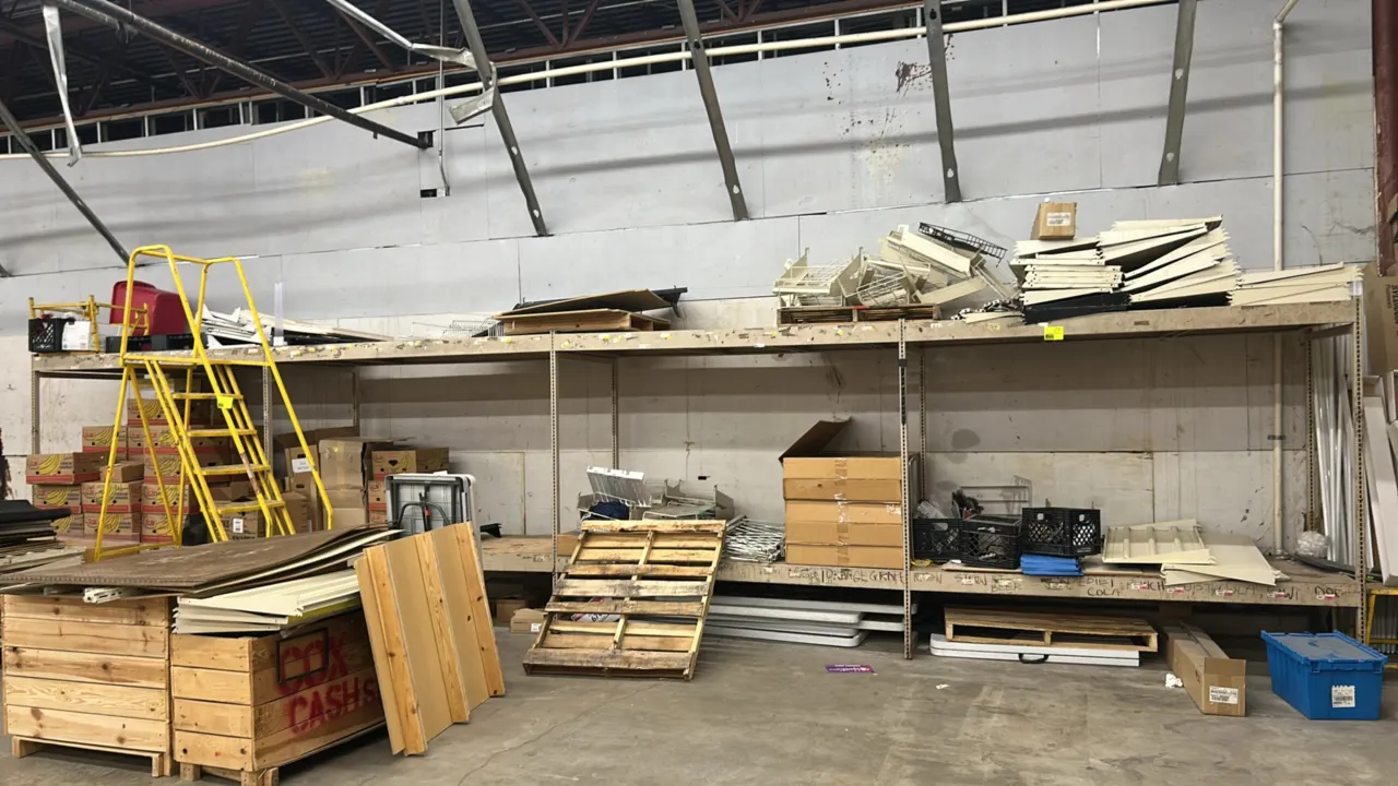 Metal warehouse racking. Features slotted steel uprights, horizontal support beams, and wood shelf decking. Dimensions: 8' x 4'. Contents and ladder n