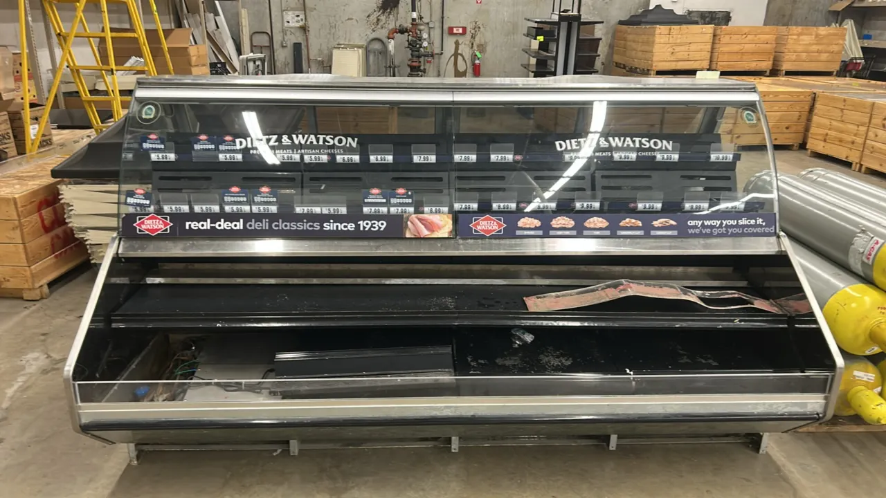 2008 Barker curved glass deli service case. Features stainless steel construction, curved front glass, 2-tier front open merchandising deck, rear slid