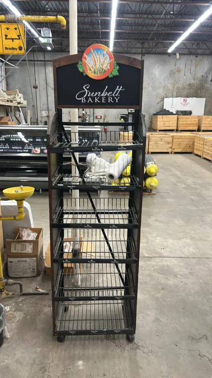 Portable multi-tier bakery merchandiser display rack. Features woodgrain laminate side panels with Sunbelt Bakery graphics, (6) slanted wire shelves w