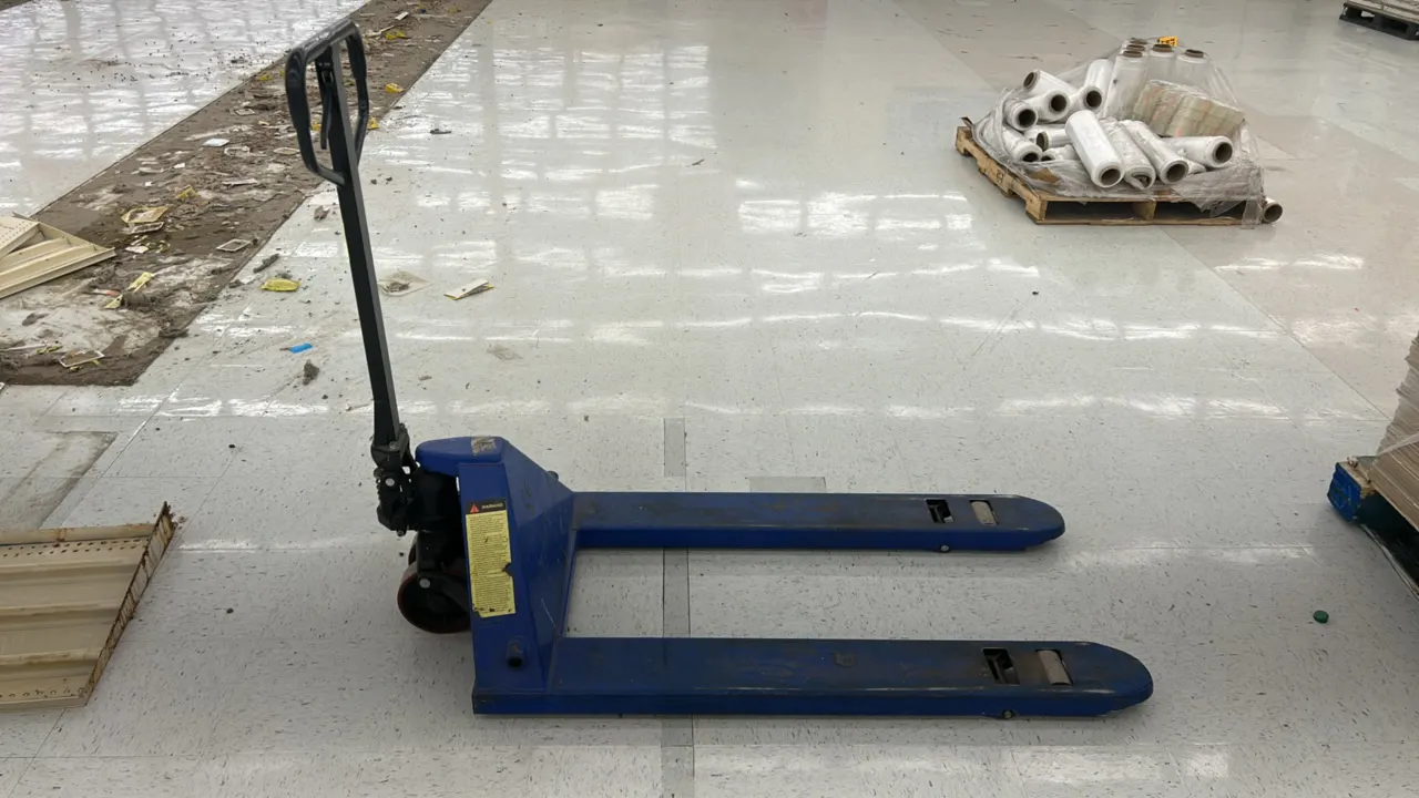Manual hydraulic pallet jack. Features steel construction with a blue finish, ergonomic loop handle with fingertip control release lever, hydraulic li