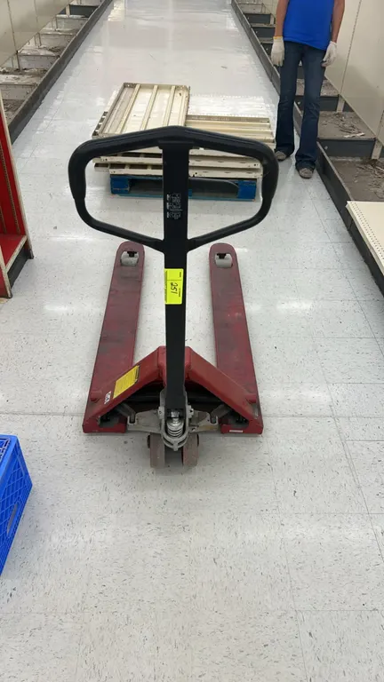 Manual hydraulic pallet jack. Features steel construction, hydraulic hand pump handle with fingertip release lever, and front load rollers.