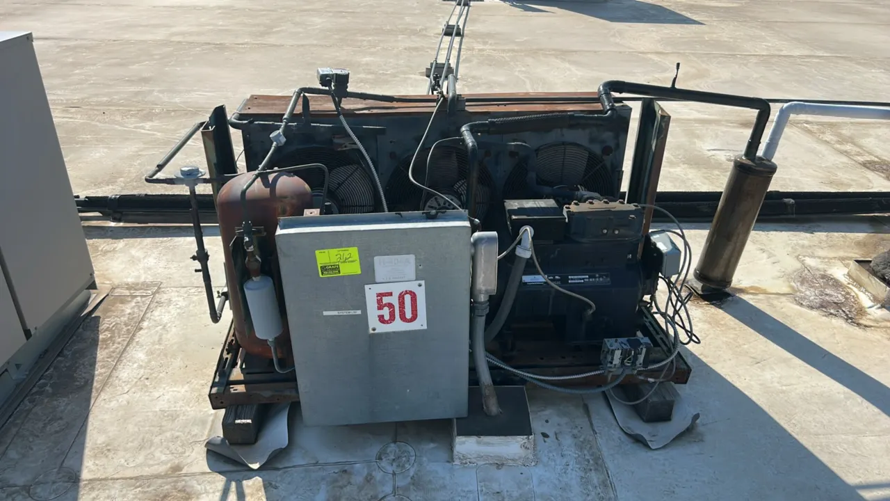 Heatcraft compressor rack. Features Copeland compressor, Copeland scroll compressor, 3-fan air-cooled condenser, receiver tank, and electrical control