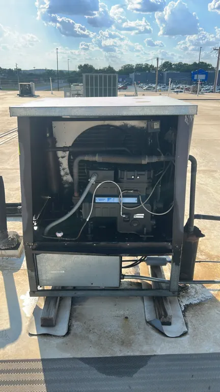 Heatcraft condensing unit with Copeland compressor. Features outdoor protective housing, condenser fan, finned coil, and suction accumulator. Refriger
