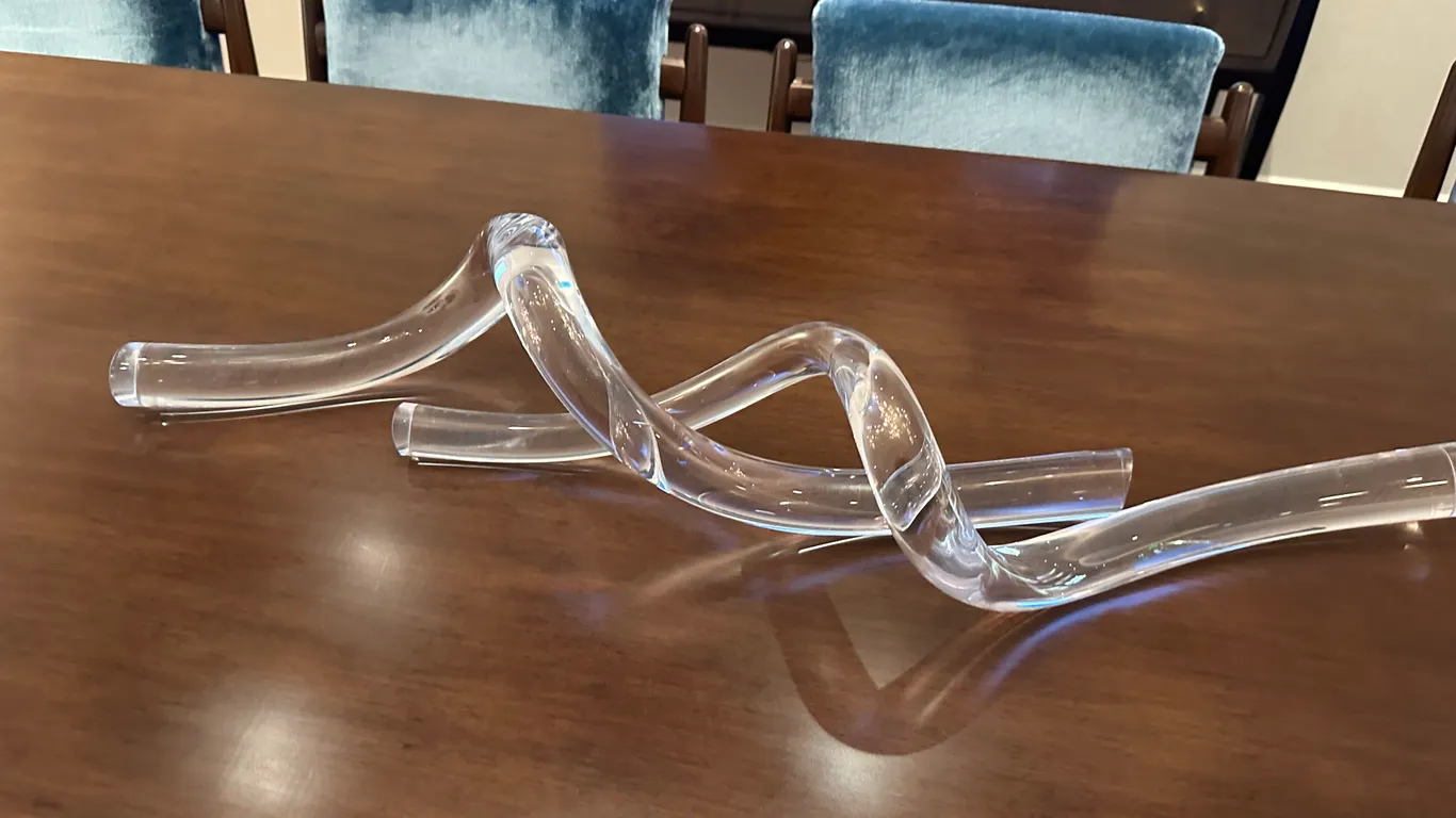 A SkLO Clear Glass Sculptural Decor Piece. (SkLO) An organic, fluid curved art glass sculpture featuring an etched "SkLO" signature at the base. Measu