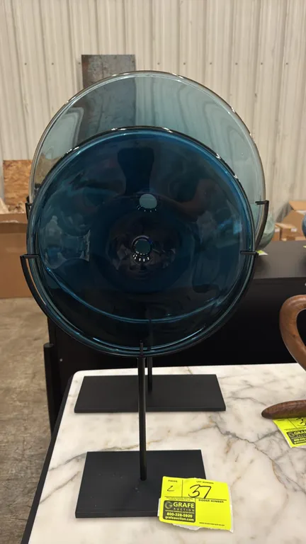 A Pair of SkLO "Pool" Hand-Blown Glass Objects. (SkLO) Two sculptural hand-blown glass discs in translucent blue tones with central pierced openings,