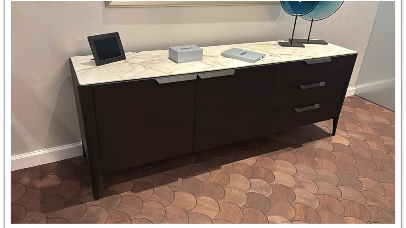 Porada Atlante sideboard. Features a solid stone top, two cabinet doors, and three drawers with horizontal pulls. Dark wood finish on tapered legs. 83