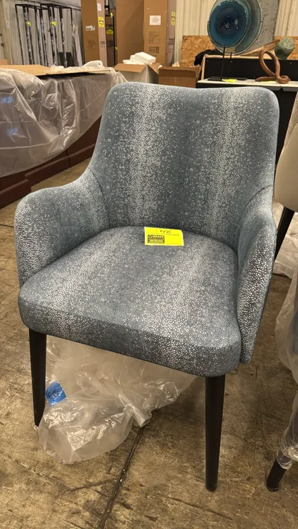 Adriana Hoyos Galapagos 100 armchair. Features blue and silver-tone stipple pattern fabric upholstery, solid blue back, integrated armrests, and padde