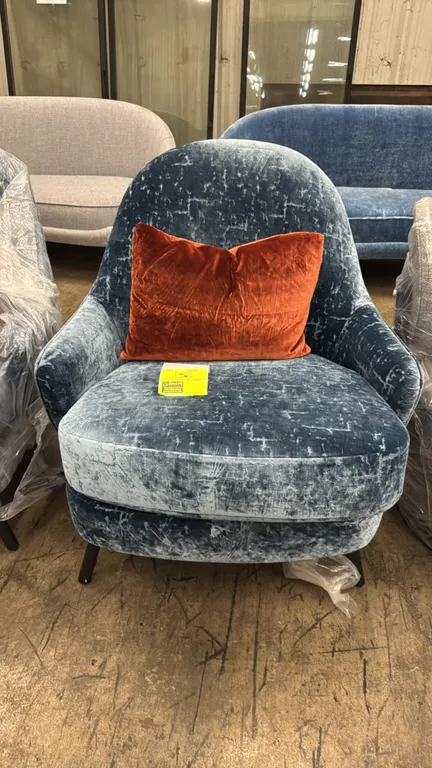 Hammer Fine Furniture upholstered lounge chair. Features blue textured velvet upholstery, a smooth blue lower back panel, and dark tapered wood legs.