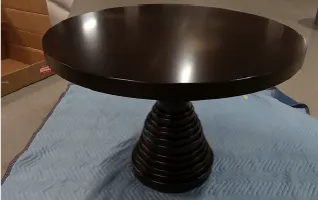 Hammer Fine Furniture Ibiza round table. Features a custom dark finish and a sculptural tiered concentric pedestal base. 42" Dia. Tabletop vase not in
