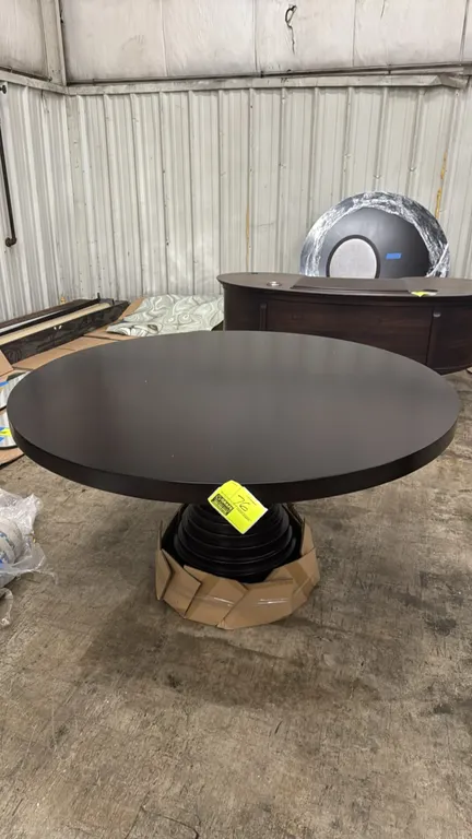 Hammer Fine Furniture Ibiza round table. Features a dark finish and round top. Mounted on a sculptural tiered pedestal base. Dimensions: 54" Dia.