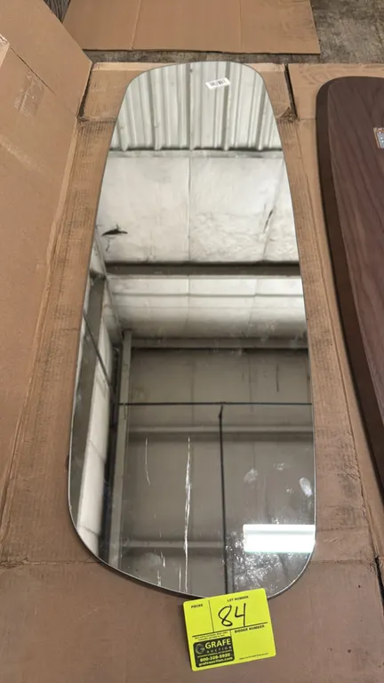 Custom asymmetrical wall mirror. Features a frameless design with polished edges and a walnut-finish wood backing panel with recessed metal mounting h