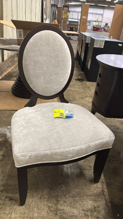 Barbara Barry oval back side chair. Features an upholstered oval back with rear X-brace detail, cushioned seat in light gray textured fabric, and a da