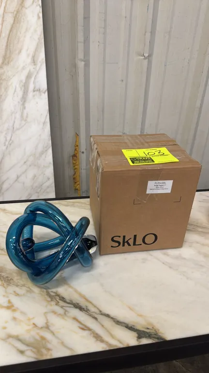 SkLO FL114SBL wrap object. Features hand-blown Czech glass in steel blue with a continuous wrapped design. 7". Includes original packaging. Note: New