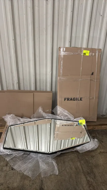 Metal framed mirror. Features an elongated hexagonal geometric shape, black metal frame, and beveled edge glass. 48"x27". Note: Item is packaged in bo