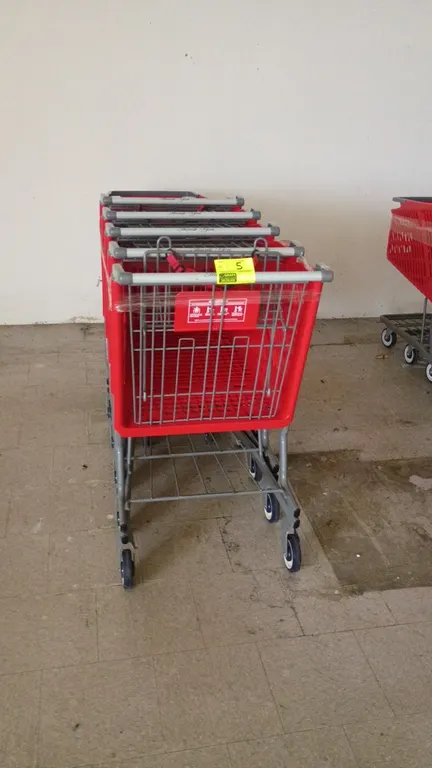 Poly shopping carts. Features red plastic baskets, gray metal frames, folding child seats with safety straps, lower wire cargo trays, and push handles