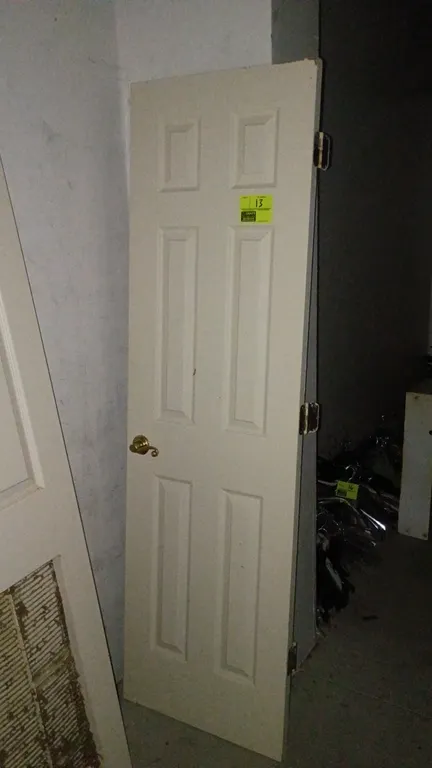 Hollow core interior door. Features a 6-panel design, off-white finish, brass-tone lever handle, and three attached hinges. Dimensions: 24"W x 80"H.