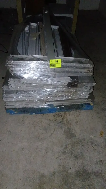 Assorted metal gondola shelving components. Includes uprights, base shoes, and accessory channels. Shrink-wrapped on a pallet.