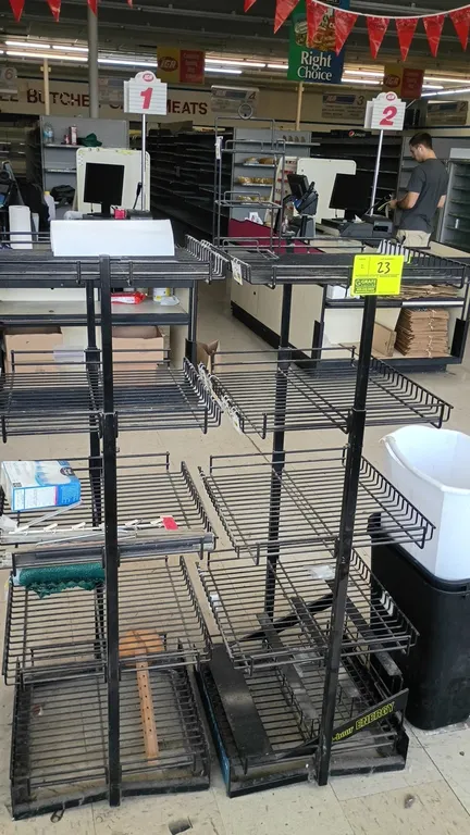 Metal 5-tier wire display rack. Features 5 wire shelves with front retaining lips and integrated price tag channels. Black finish. Dimensions: 18" x 1