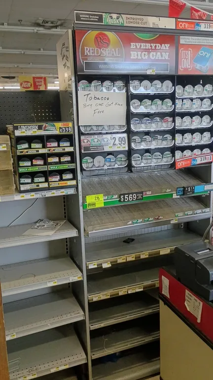 Merchandise display rack. Features multi-tier adjustable metal shelving, spring-loaded canister pusher displays, plastic bins, and overhead signage he