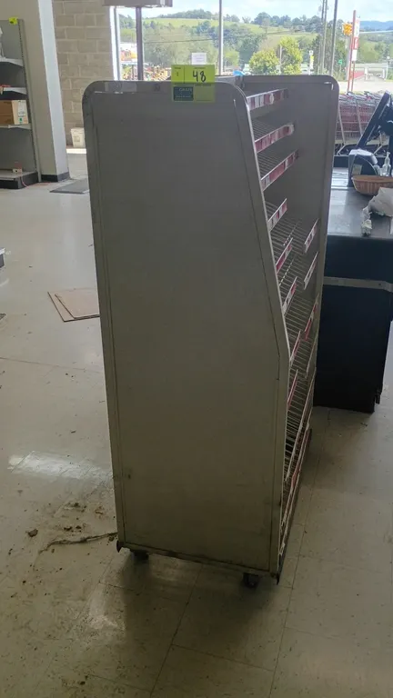 Portable check lane candy merchandisers. Features dual-sided display with slanted wire shelves and tag molding on one side, and pegboard backing with