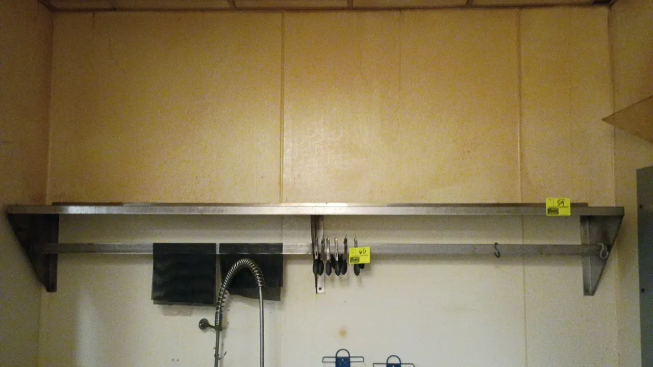 Stainless steel wall-mounted shelf. Features an integrated lower hanging bar and three heavy-duty wall brackets. Dimensions: 108"L x 15"W x 18"H. Cont