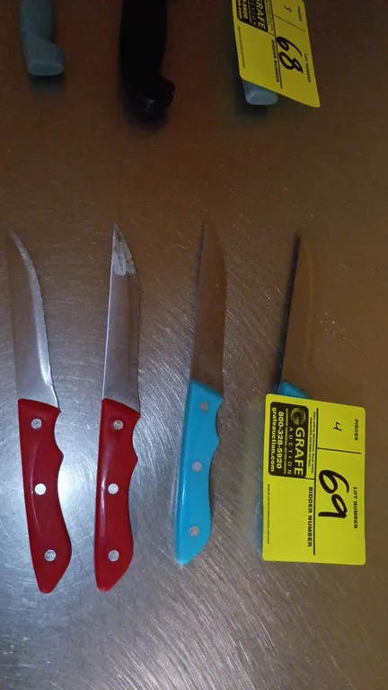Assorted kitchen utility knives. Features stainless steel blades with molded plastic contoured handles in red and blue with triple-rivet design.